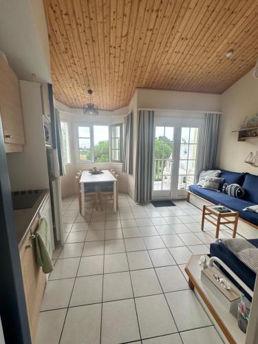 un salon avec un canapé bleu et une table dans l'établissement Duplex lumineux, à Saint-Jean-dʼOrbetiers