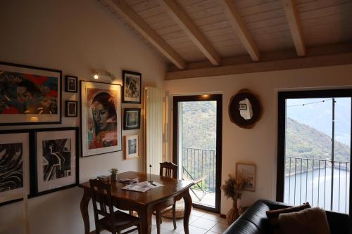 a living room with a table and a balcony at Bright studio with panoramic view of Valle Verzasc in Mergoscia