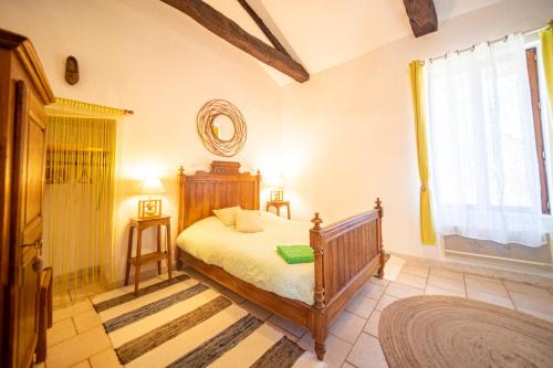 a bedroom with a bed and a window at Les Copains à Bord in Saint-Julien-dʼArpaon