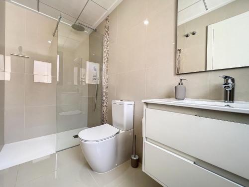 Un baño blanco con inodoro y lavabo. en Villa Hestia, en Alicante