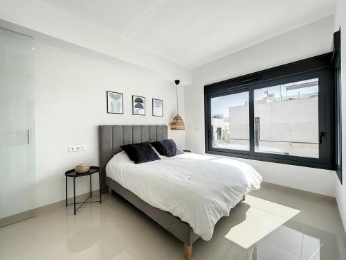 Un dormitorio con una cama y una ventana grande. en Villa Hestia, en Alicante