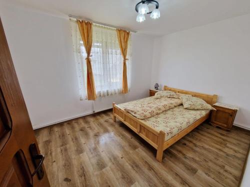 a bedroom with a bed and a window at Cabana Poiana Dealul Frumos in Gîrda de Sus