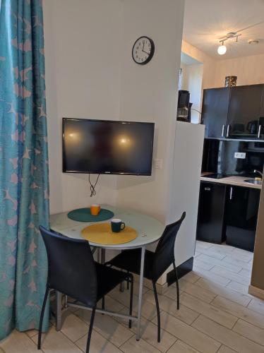 d'une petite table et de chaises dans une cuisine équipée d'une télévision. dans l'établissement SCI les THERMES 17, à Rochefort
