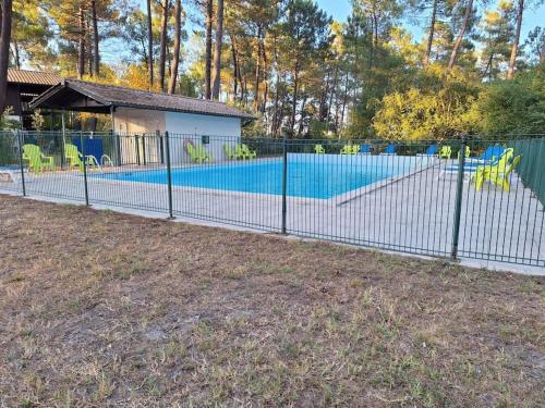 une clôture en face d'une piscine dans l'établissement Chalet lacanau, à Lacanau