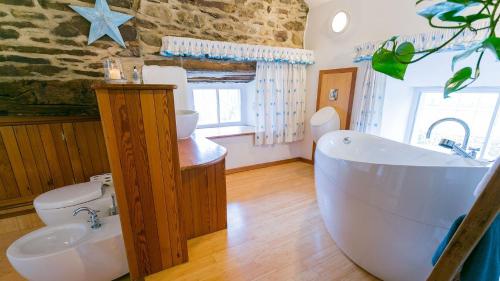 a bathroom with a tub and a toilet and a sink at Tal y Bont Barns in Bangor