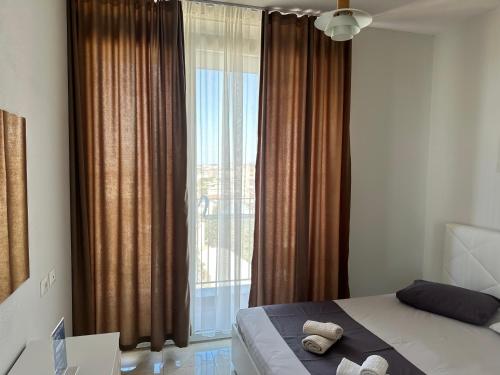 a bedroom with a bed and a large window at Luxury Apartment with Parking in Tirana