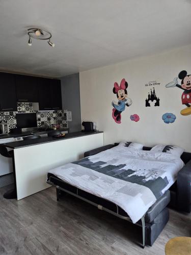 1 dormitorio con un mural de ratón Mickey en la pared en Studio à 2 pas de Disneyland, en Esbly