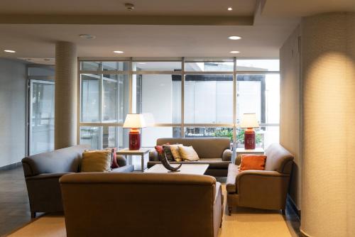 a lobby with two couches and a table and windows at Hotel PAX Torrelodones in Torrelodones