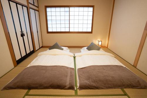 uma cama grande num quarto com uma janela em 大吉屋本館 ワンフロア貸切部屋 名駅離れ em Nagoya