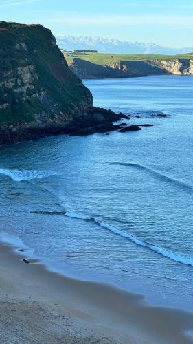 a view of a beach with the ocean and mountains at Apartamentos Olga Cantabria 2 in Polanco