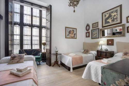 エル・プエルト・デ・サンタマリアにあるExclusivo Apartamento En Palacioのベッドルーム1室(ベッド2台、ソファ、椅子付)