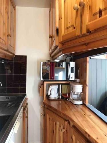 une cuisine avec des armoires en bois et un comptoir dans l'établissement BOR52 - BEAU T2 Rénové - pied des pistes- VAL CLARET, à Tignes