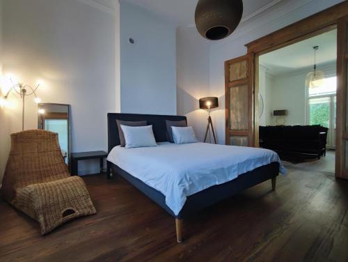 a bedroom with a large bed and a living room at Le Liégeois - proche centre - Maison de maître in Liège