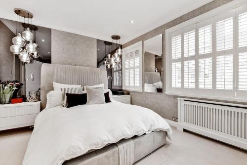 a bedroom with a large white bed and windows at Chic 3-Bed Townhouse,2 Mins to Windsor's Long Walk in Windsor