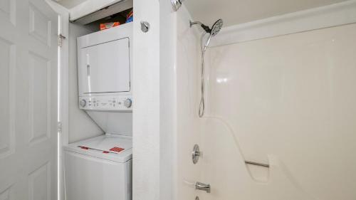 a bathroom with a shower and a washer and dryer at The Larks Landing by Last Key Realty in Key West