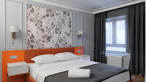 a bedroom with a bed with an orange headboard and a window at OTTO Tunalı Houses in Ankara