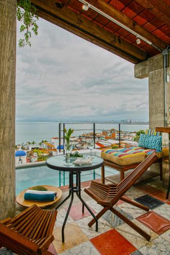 a patio with a table and chairs and the ocean at Casa Pancha Puerto Vallarta Centro - Adults Only in Puerto Vallarta