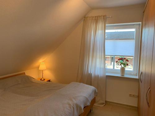 a bedroom with a bed and a window at Haus-am-See-Kolkstr-1-OG-rechts in Norddeich