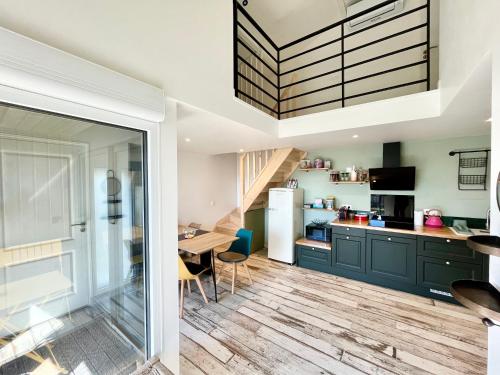 Il comprend une cuisine avec des placards verts et du parquet. dans l'établissement L'Escapade - PARIS 20 min - DISNEY 25 min - GARE 3 min à pied - PARKING - Confortable & Moderne - Free WIFI, à Pomponne