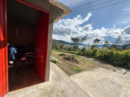 a red door of a red house with a view at Vista al Lago, Cabaña Privada in Pasto