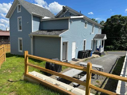 a blue house with a wooden fence in front of it at 3rd Base Apt 2 All Star Baseball Rentals in Oneonta
