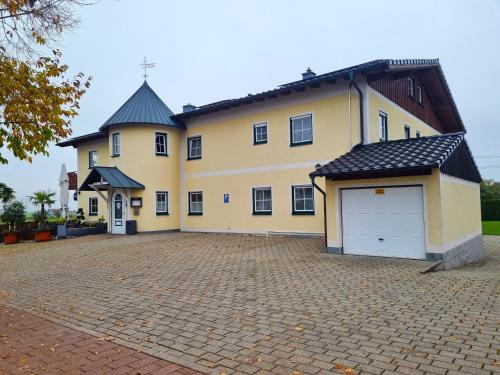 a large yellow house with a large driveway at Zur Turmstube in Dossenheim