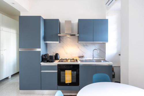 Una cocina con gabinetes azules y un fregadero. en Dreams Little Apartment - M5 Station - Near Center, en Milán