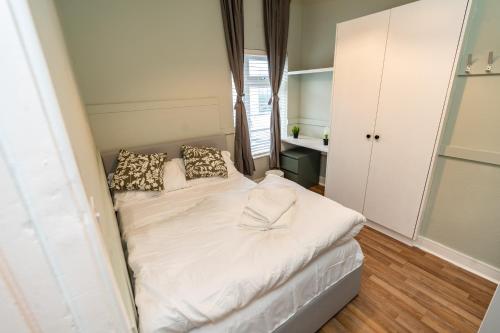 a small bedroom with a bed with white sheets and pillows at Talbot Street Guest House in Dublin