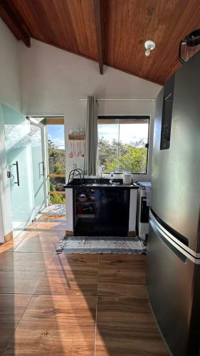 a kitchen with a stainless steel refrigerator and a window at Vila Verde in Palmeiras