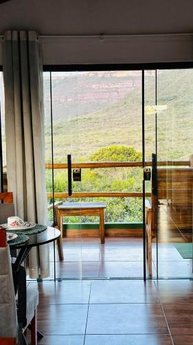 a living room with a large glass door with a table at Vila Verde in Palmeiras