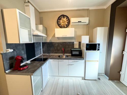 a small kitchen with white cabinets and a sink at Domaine Les feuilles de Chêne in Carpentras