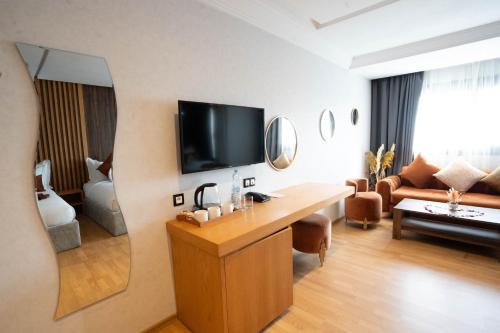 a room with a living room with a television and a couch at Razane Hôtel in Kenitra