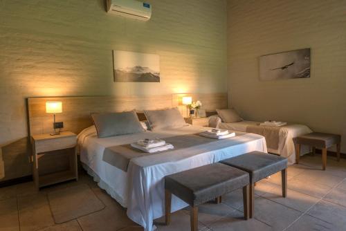 a hotel room with a large bed and a couch at Posada Mawida in Maipú