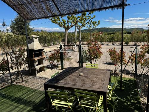 a patio with a table and chairs and a grill at Domaine Les feuilles de Chêne in Carpentras