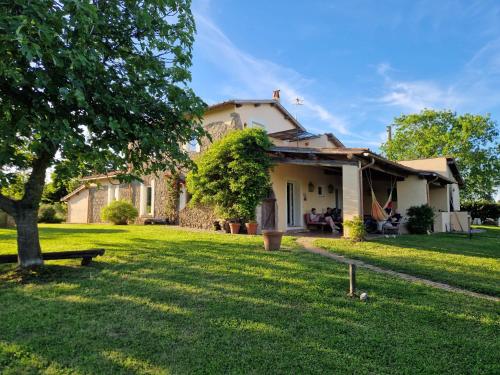a house with a green yard in front of it at Casale Le Pietre in Marta