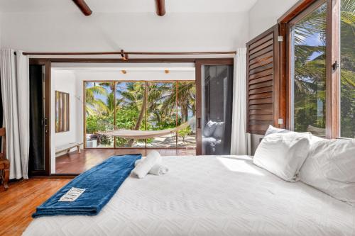 a bedroom with a bed with a view of a hammock at La Perla del Caribe - Villa Amber in San Pedro
