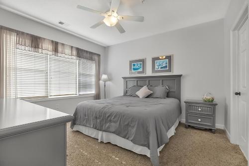 a bedroom with a bed and a ceiling fan at The Norman Retreat At Barefoot Resort! 3 Bedroom in Myrtle Beach