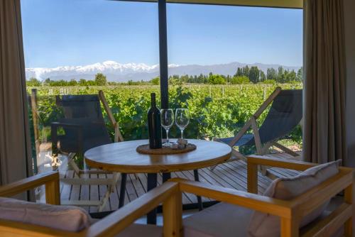 a table with wine glasses and a view of a vineyard at Posada Mawida in Maipú
