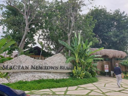 a man walking past a sign that reads virginuanauanauana beach at One Pacific Residence Condominium Tower C-16N in Mactan