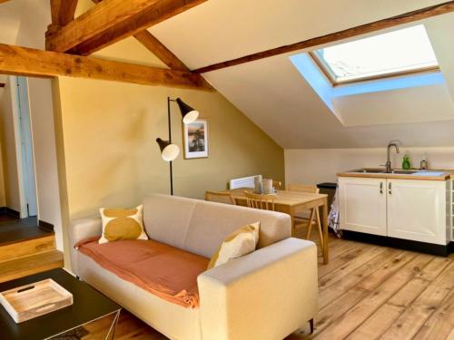 un salon avec un canapé et une cuisine dans l'établissement Sous les Toits de Wambrechies, à Wambrechies