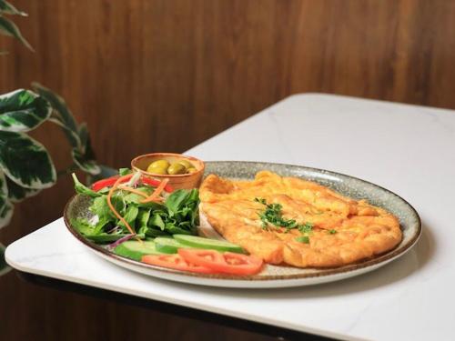 a plate of food on a table with vegetables at فندق المدينة القديمة Old Town Hotel in Nizwa
