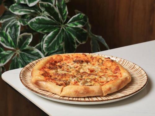 a pizza sitting on a plate on a table at فندق المدينة القديمة Old Town Hotel in Nizwa