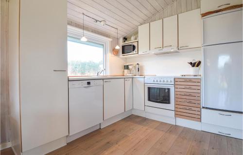 una cucina bianca con elettrodomestici bianchi e una finestra di Holiday Home Sønder Vasevej Blåvand Iv a Blåvand