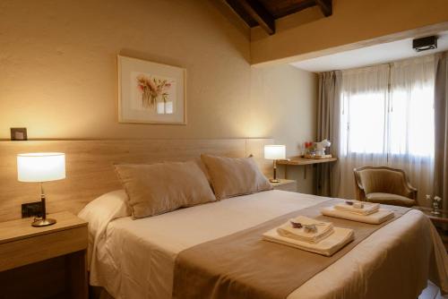 a bedroom with a bed with two towels on it at Posada Mawida in Maipú