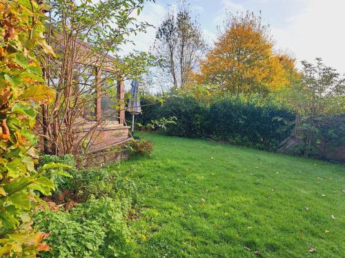 a backyard with a yard with green grass and a fence at Gîte al fontaine in La Roche-en-Ardenne