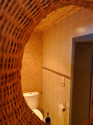 a bathroom with a toilet and a wicker wall at Gîte al fontaine in La Roche-en-Ardenne