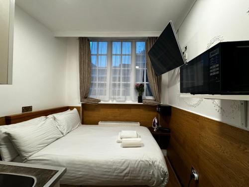 a bedroom with a bed with a tv and a window at Berkley Apartments in London