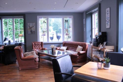 a living room with leather chairs and a table at Landgasthof Wildwasser in Wolthausen