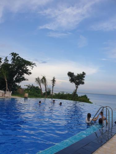 a group of people in a swimming pool near the ocean at One Pacific Residence Condominium Tower C-16N in Mactan