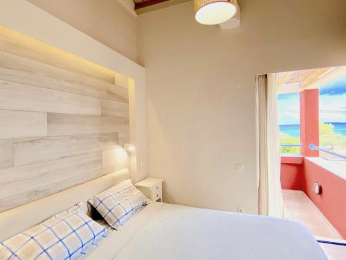 a bedroom with a white bed and a window at Barbati Alpha MiniVilla by DadoVillas in Barbati